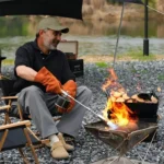 A long-nozzle butane torch with a wooden handle is attached to an Iwatani gas canister, emitting a powerful blue flame